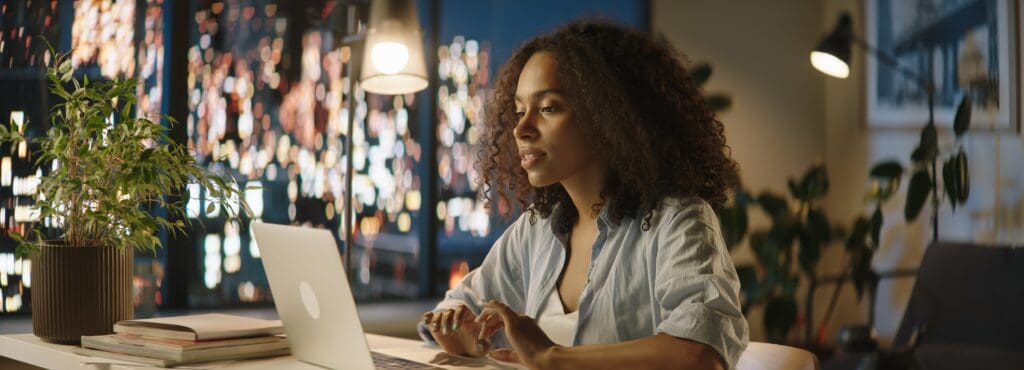 Portrait of woman staying up late, using her laptop to work or study