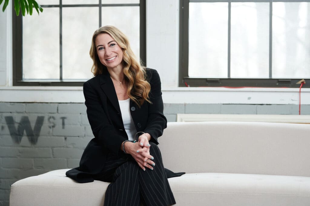 Picture of Dr Natalie Dattilo-Ryan sat down an a white sofa