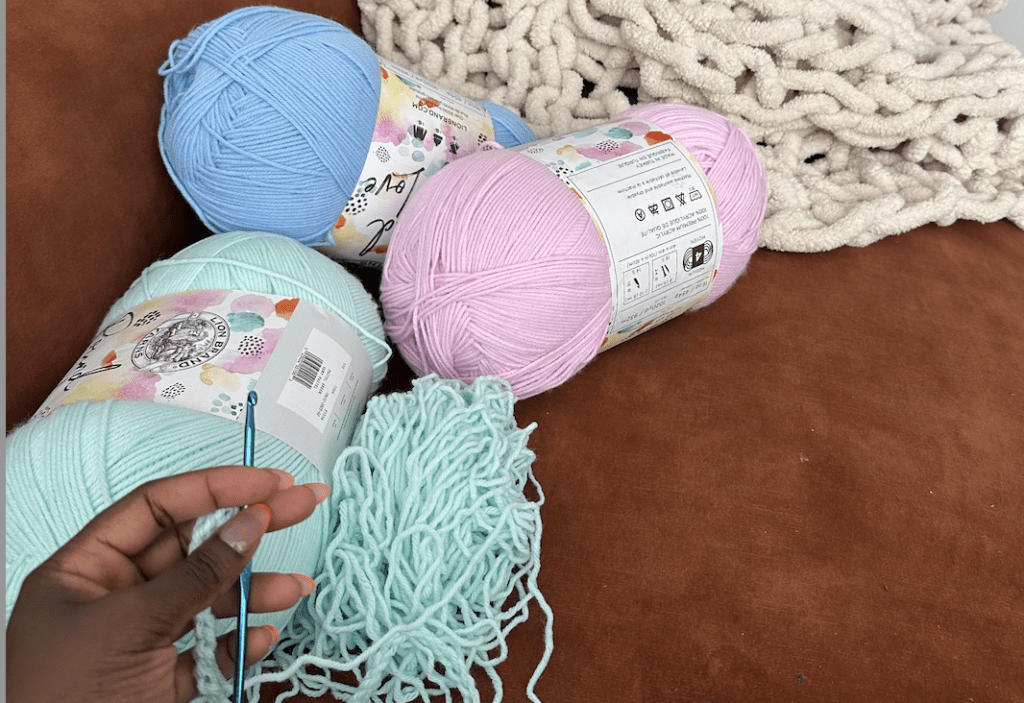 several crochet yarn balls: pink, light blue and dark blue 