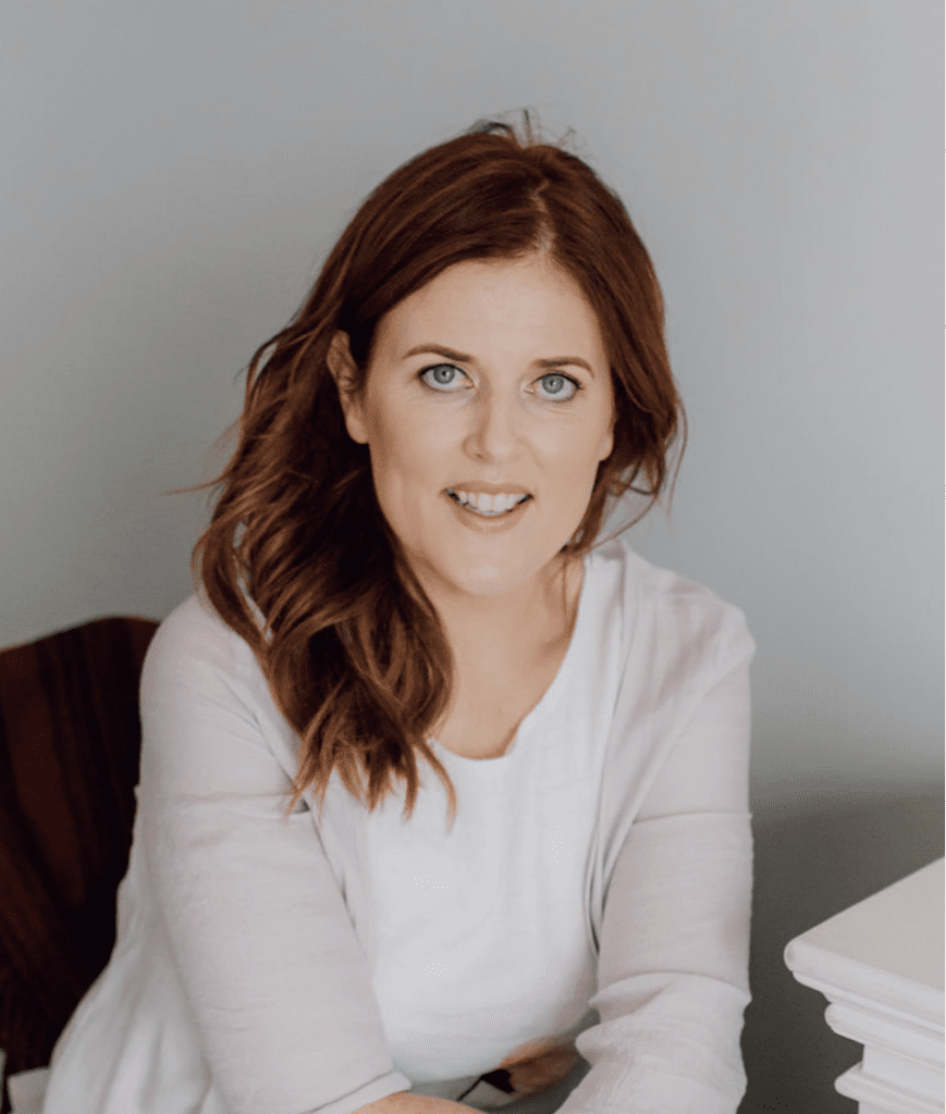 Woman with white long-sleeves shirt sitting and smiling at camera