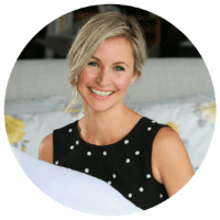 woman in polka-dot tank top with short blonde hair smiling at camea. 