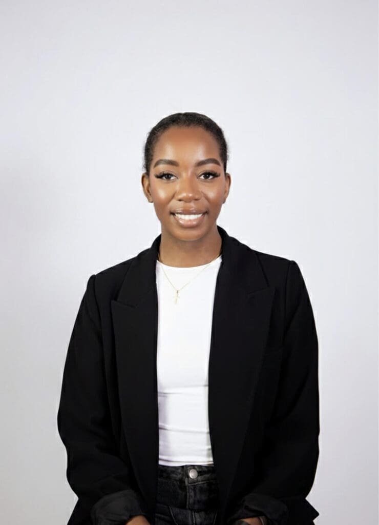Woman wearing white shirt and black blazer smiling at camera 